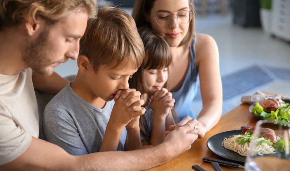 família agradecendo a deus pela comida